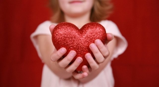 Фото Девочка держит в руках игрушечное красное сердце