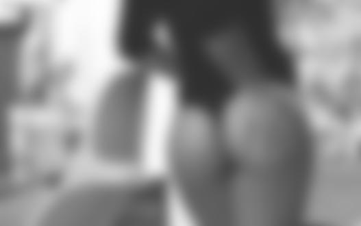 Фото Девушка в черных трусиках и кофте прислонила руку к попе