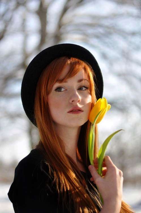 Фото Рыжеволосая девушка в шляпке с желтым тюльпаном у лица