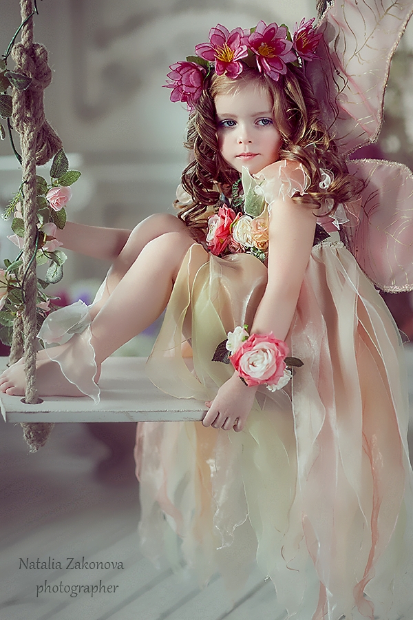 Фото Девочка с венком из цветов на голове и шикарном платьице сидит на качели, фотограф Наталья Законова