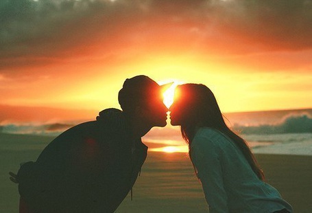 Пара целуется на фоне заката