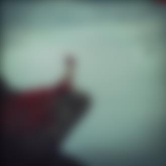 Фото Обнаженная девушка, с красной тканью, сидит на краю скалы над морем, фотограф Эндрю Лукас / Andrew Lucas