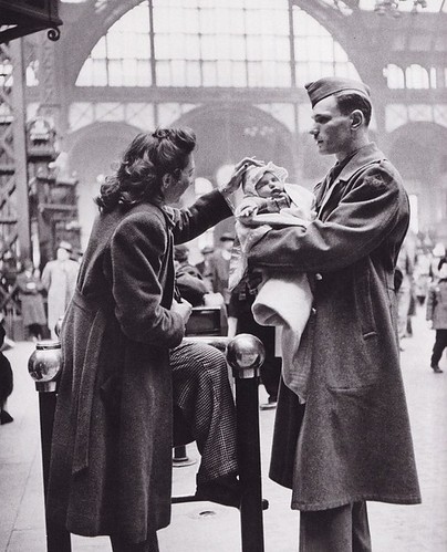 Фото Солдат держит своего малыша на руках на вокзале, и смотрит на свою жену которая поправляет шапочку ребенку, фотограф Alfred Eisenstaedt