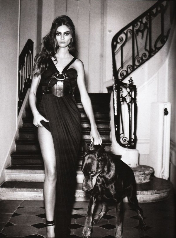 Фото Итальянская модель Бьянка Балти / Bianca Balti в черном платье стоит около лестницы с собакой породы доберман