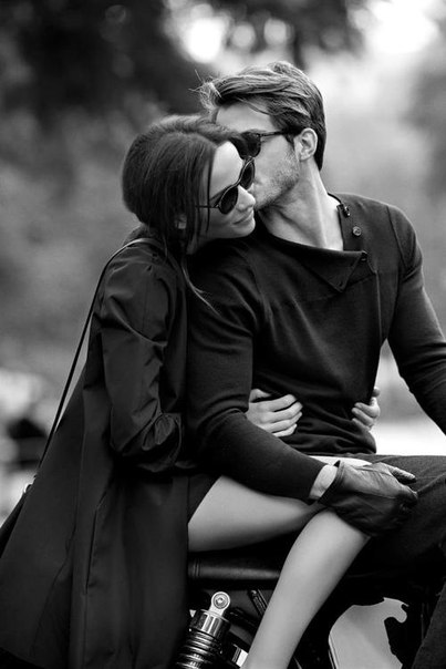 Фото Мужчина целует девушку в щеку, оба сидят на мотоцикле