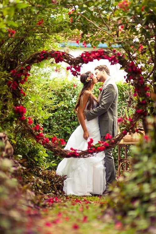 Фото Жених и невеста целуются среди сердца из цветов