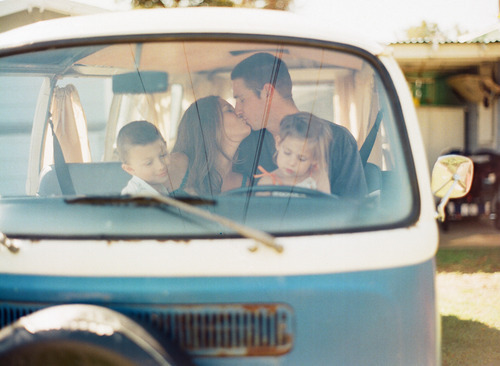 Фото Мужчина с женщиной целуются сидя в машине, рядом с ними сидят их дети
