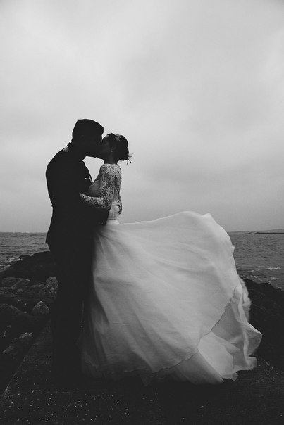 Фото Девушка с мужчиной целуются стоя на ветру у моря