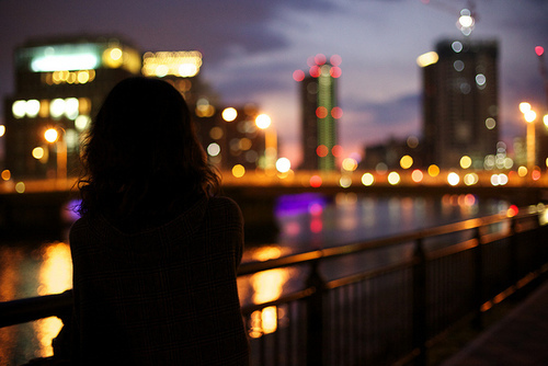 Фото Силуэт девушки, которая стоит на мосту, любуясь на ночной город