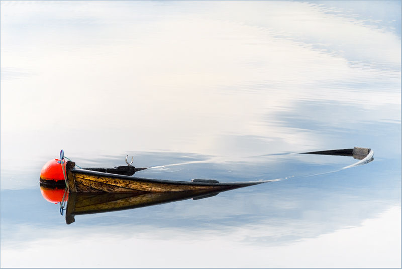 Фото Затонувшая в воде деревянная лодка, рядом с ней находится красный буй, фотография Йона Колбенсина / John Colbensen