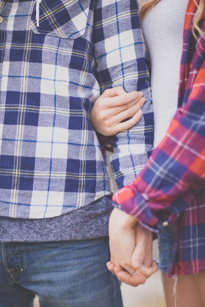 Фото Девушка с мужчиной в клетчатых рубашках держатся за руки