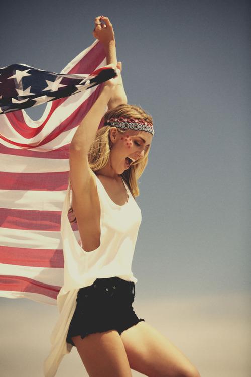 Фото Девушка бежит, держа за спиной американский флаг