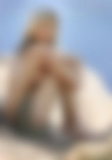 Фото Обнаженная девушка сидит на скале, обхватив руками колени, автор Sylvio Testa / Сильвио Теста