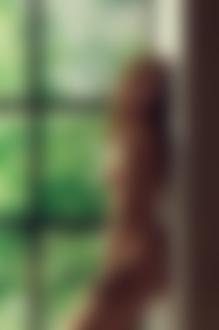 Фото Обнаженная девушка стоит у окна с закрытыми глазами, за окном видны деревья, фотограф Vladimir Tikhorskiy / Владимир Тихорский