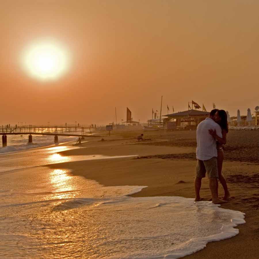 Фото Парень с девушкой в объятиях на берегу моря во время заката