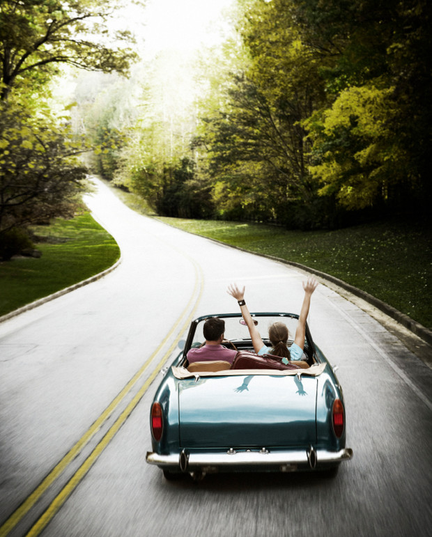 Фото Девушка с мужчиной едут в автомобиле по дороге среди леса
