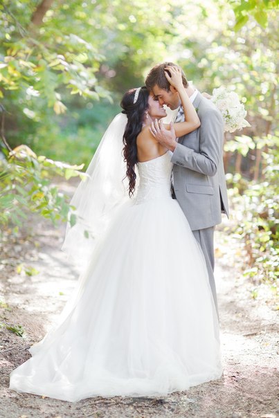 Фото Мужчина и девушка в свадебном платье, стоят на лесной дороге