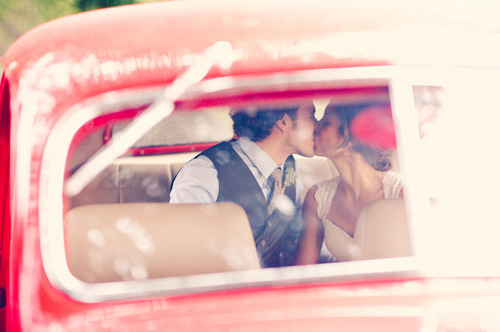 Фото Девушка с парнем целуются, сидя в красной машине
