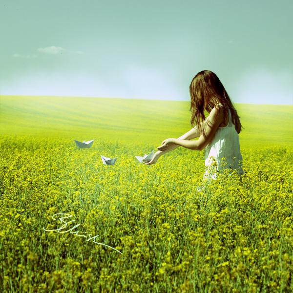 Фото Девушка в поле с желтыми цветами пускает бумажные кораблики, фотограф B. Christina