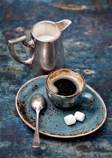 Фото Кофе в маленькой чашке которая стоит на тарелке, рядом лежит ложка и зефир, также стоит молоко