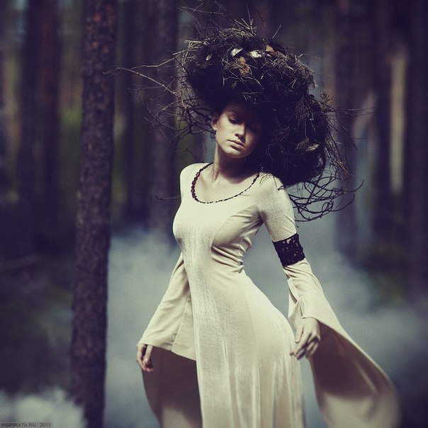 Фото Девушка в белом платье и с прической из веток стоит на фоне деревьев и дыма, фотограф Mikaella Speranskaya