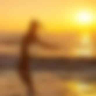 Фото Обнаженная девушка на берегу моря на фоне солнца