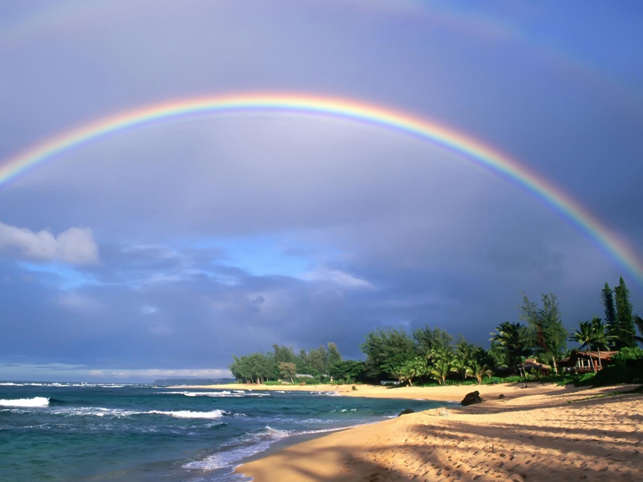 Фото Над морским берегом виднеется радуга