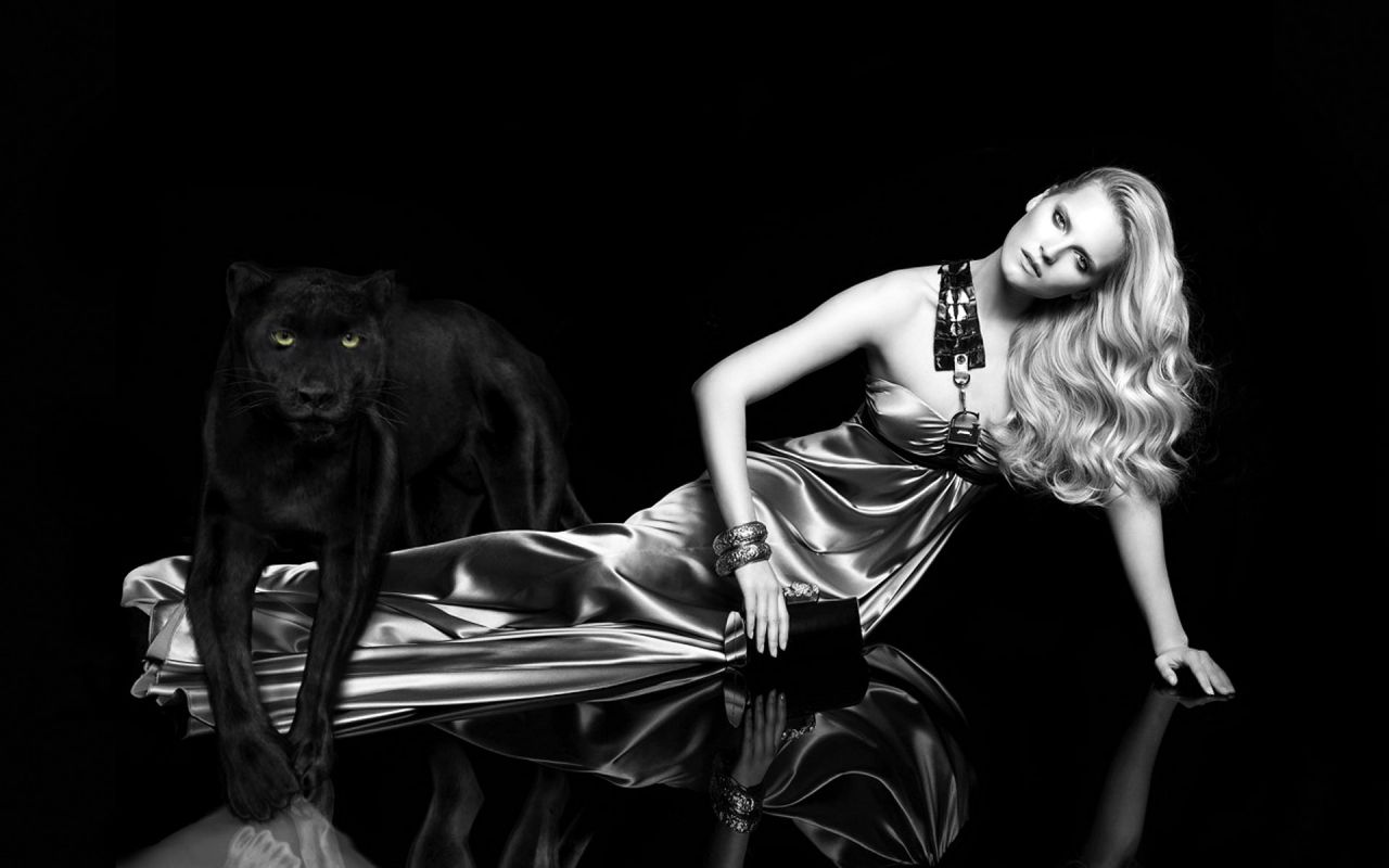 Фото Девушка полулежит на темном фоне рядом с ней черная пантера