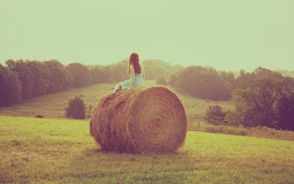 Молодая девушка голая в поле на стоге сена