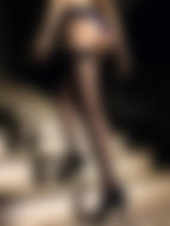 Фото Девушка в черных чулках со стрелками и в туфлях на высоком каблуке поднимается по лестнице