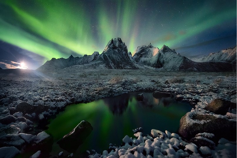 Фото Северное сияние в небе над заснеженными горами и небольшим озером, фотограф Марк Адамус / Marc Adamus