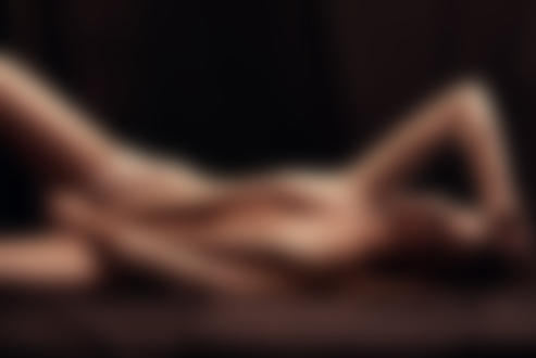 Фото Полуобнаженная девушка с жемчужным браслетом на запястье лежит, закинув руку за голову и закрыв глаза