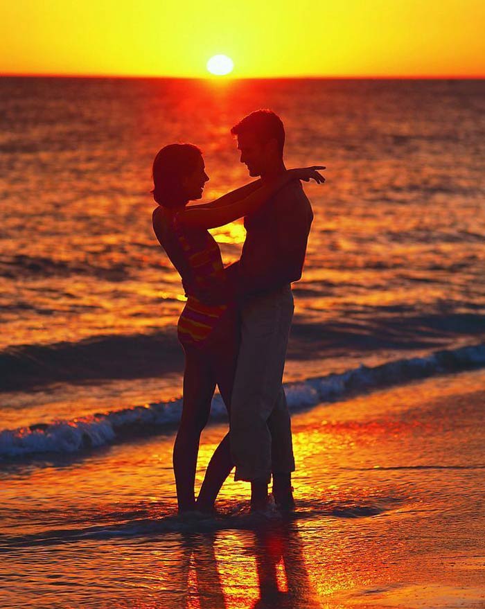 Фото Парень и девушка нежно обнимают друг друга на берегу моря на закате солнца