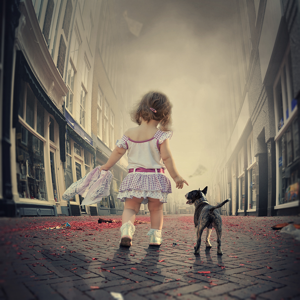 Фото Девочка с собакой породы бультерьер идут по городской улице