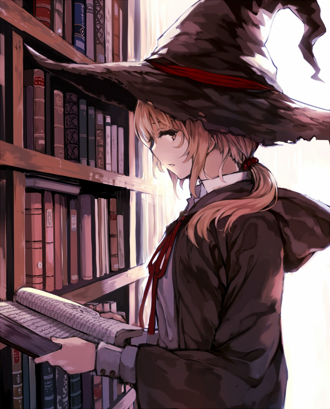 Фото Девушка в шляпе ведьмы держит в руках книгу