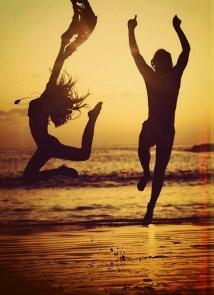 Фото Парень и девушка прыгают на берегу моря на закате