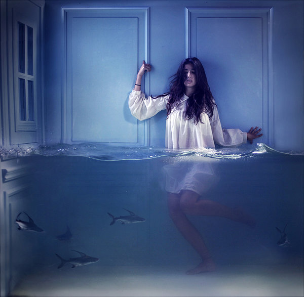 Фото Девушка в белой пежаме прижалась к стене стоя в воде, в которой плавают акулы, by Lara Zankoul