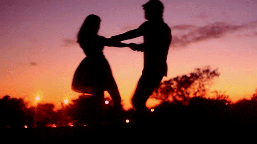 Фото Мужчина и девушка кружатся на фоне закатного неба