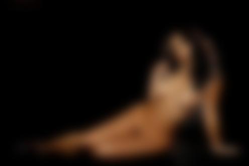 Фото Обнаженная девушка украшенная жемчугом сидит на черном фоне