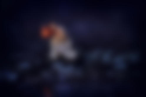 Фото Обнаженная по пояс девушка, держащая в руке зажженный фонарь, сидящая на камнях в ручье ночью