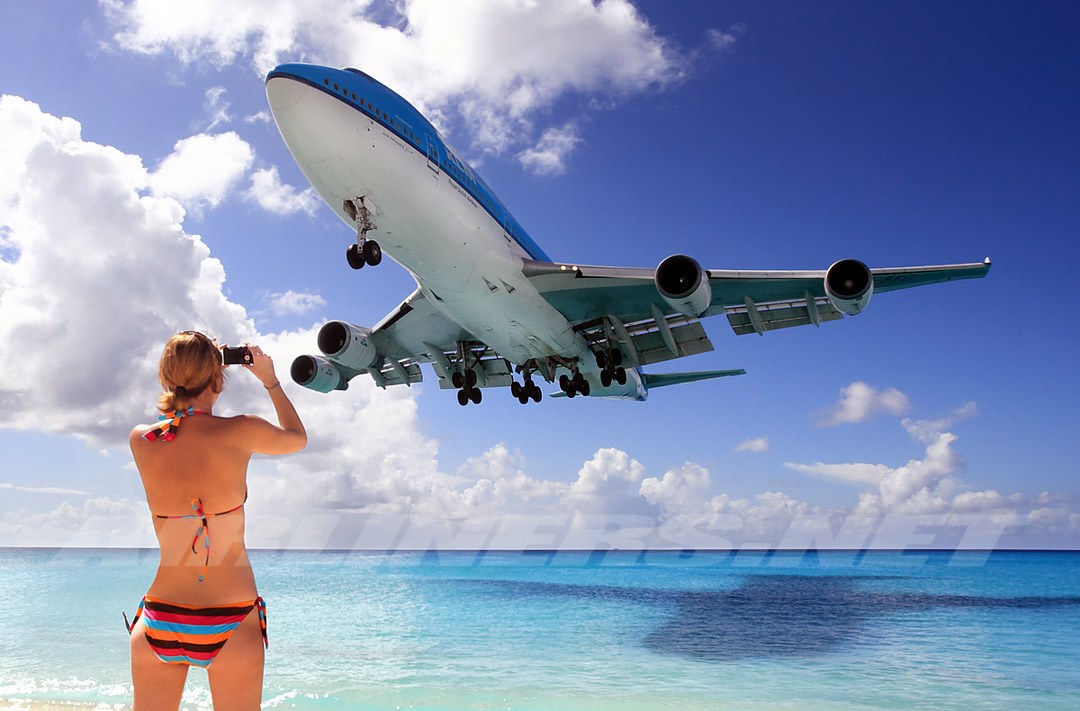 Фото Девушка в купальнике фотографирует пролетающий мимо пассажирский самолет