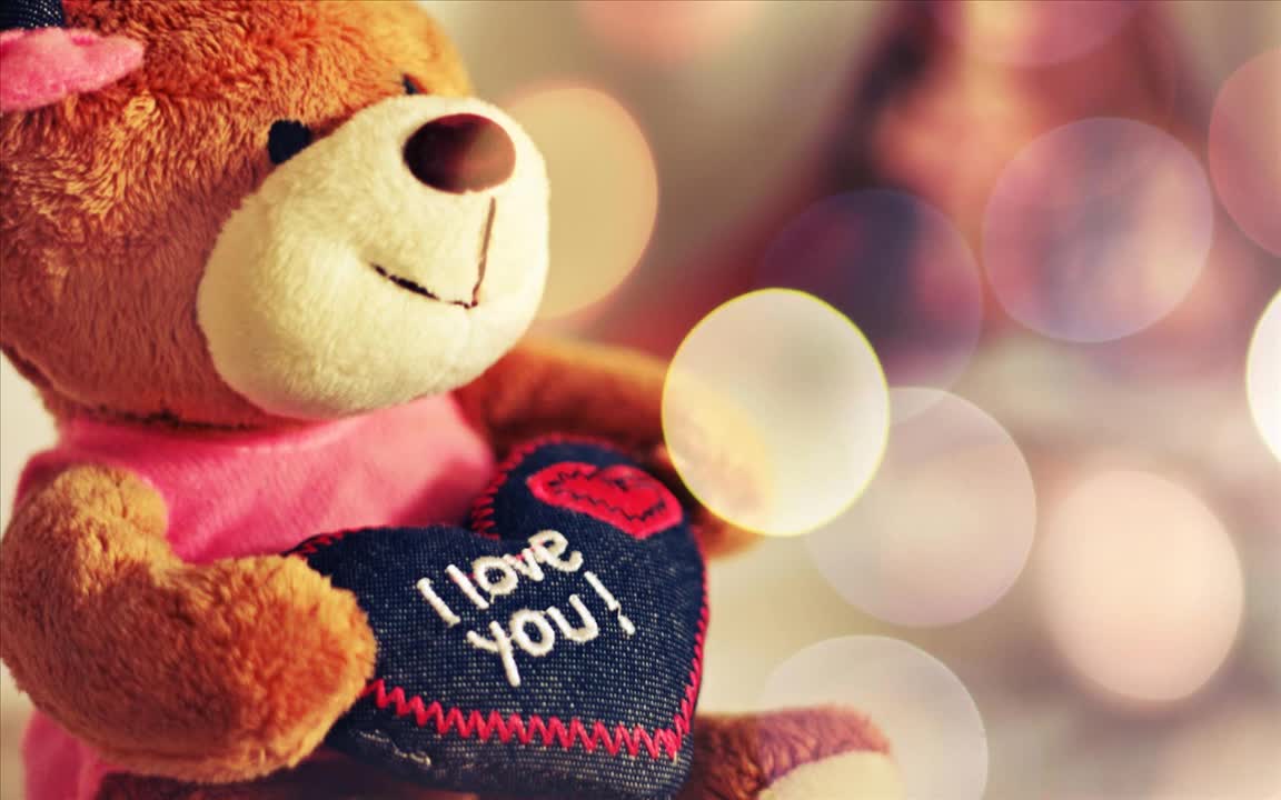 Фото Плюшевый медвежонок с сердчечком в лапках, на котором написано I love you / Я тебя люблю