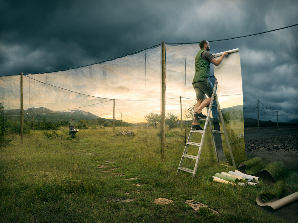 Фото Мужчина вешает на веревку обои с реалистичным пейзажем