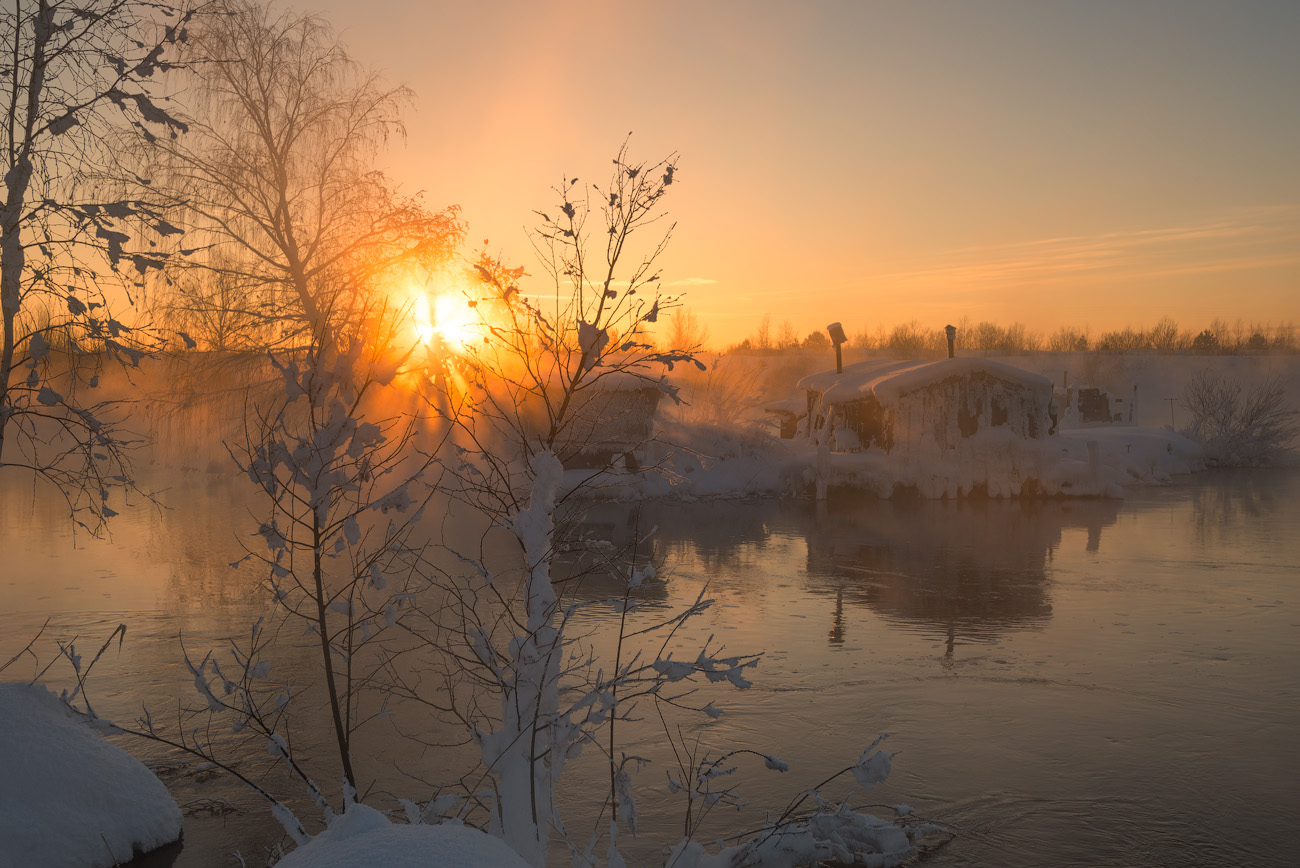 Стояло раннее утро солнце освещало верхушки. Река с льдинами утром в солнце.