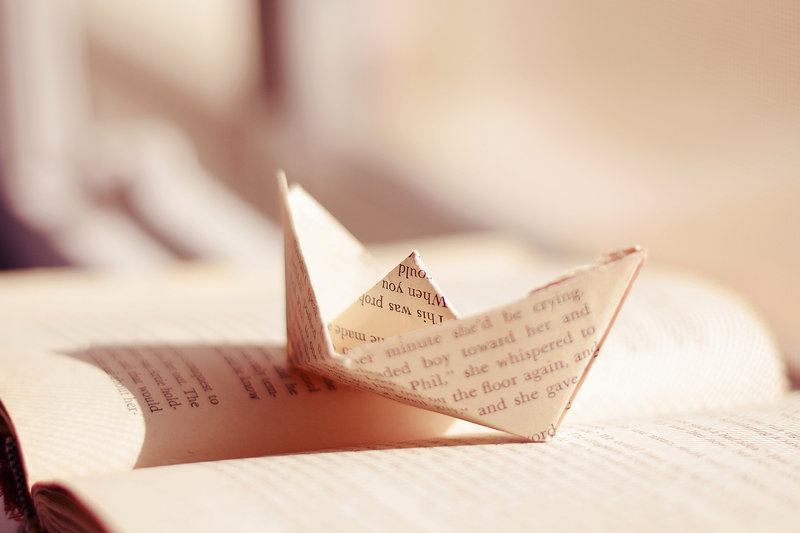 Фото Бумажный кораблик из книжного листа на открытой книге