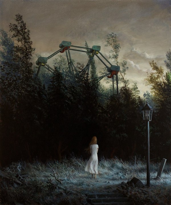 Фото Девушка в белом платье стоит напротив заросшего лесом колеса обозрения