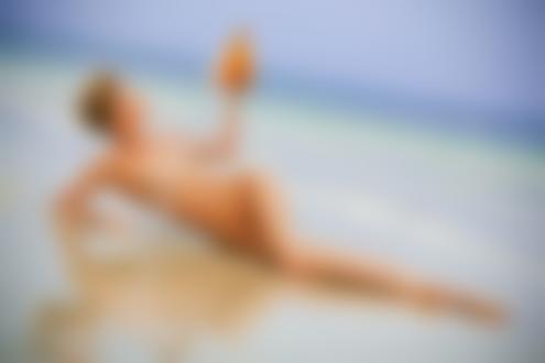 Фото Обнаженная девушка лежит на берегу моря и поливает свое тело водой из ракушки, фотограф Полянцев Филипп