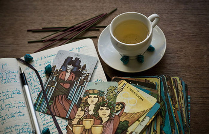 Фото Чашка чая, колода карт Таро и ручка в блокноте