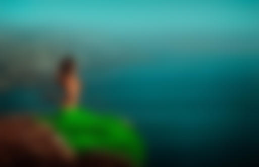 Фото Девушка в зеленой юбке, прикрывая обнаженную грудь, сидит на скале над морем, фотограф Светлана Беляева