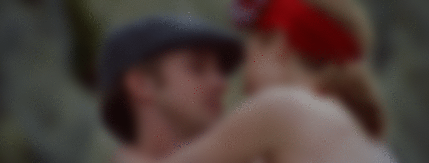 Фото Мужчину в кепке, который взял на руки полуобнаженную женщину и целует, волной смывает их к берегу